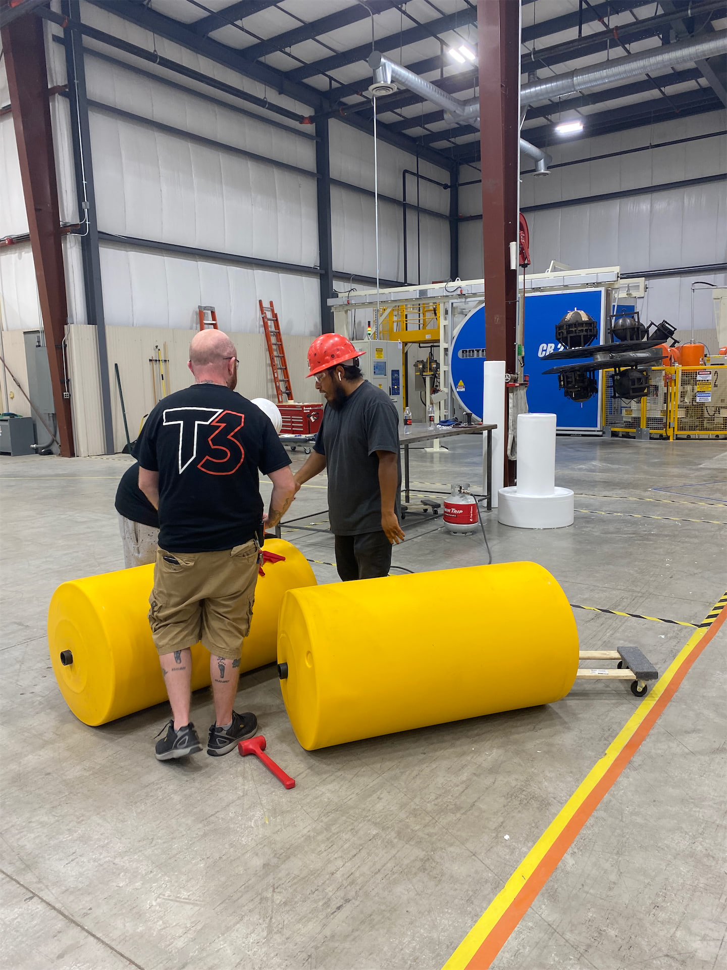 Two employees talking on the T3 manufacturing floor.